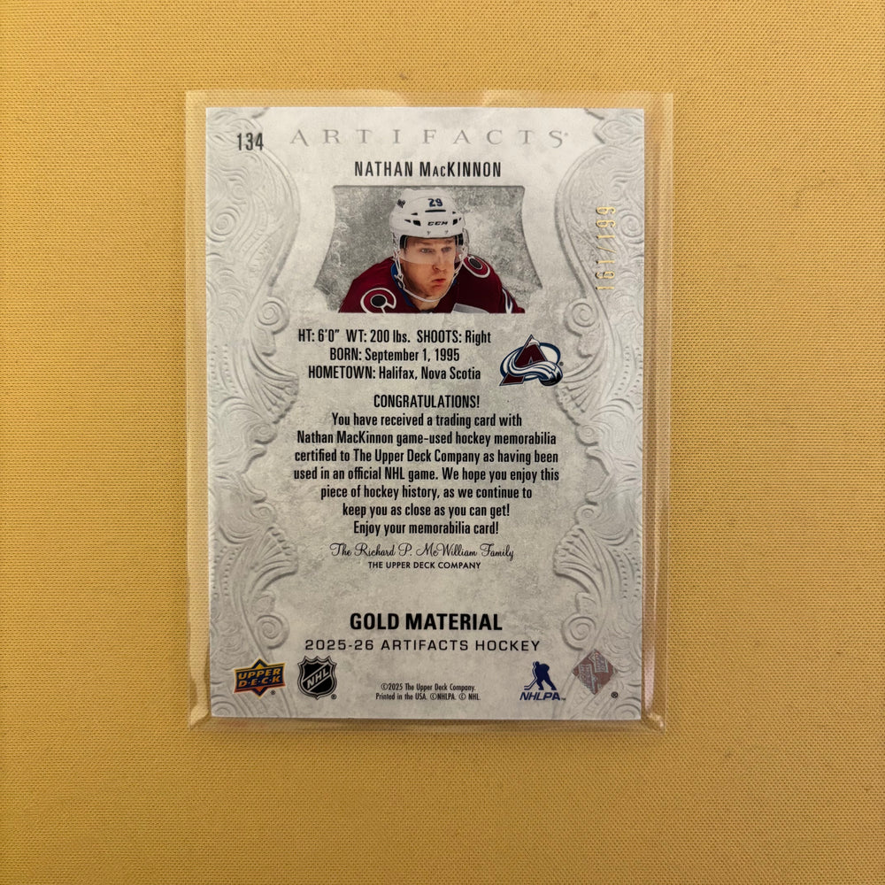 2025/26 Upper Deck Artifacts Gold Material Jersey Nathan MacKinnon /199 Colorado Avalanche #134 Sports Card